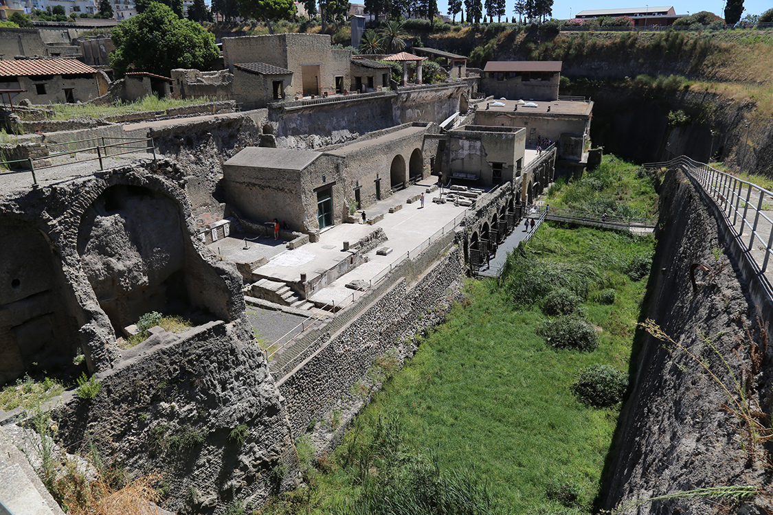 Herculaneum.
Cette ville a Ã©tÃ© recouverte de boue lors de l'Ã©ruption du VÃ©suve en 79 aprÃ¨s JC.
La vieille ville semble Ãªtre dans un trou, car l'Ã©paisseur de sÃ©diments volcaniques atteint environ 20m.
Ici, on est devant la porte marine, face Ã  la mer. Mais le front de mer a reculÃ© de plus de 500m aprÃ¨s l'Ã©ruption.